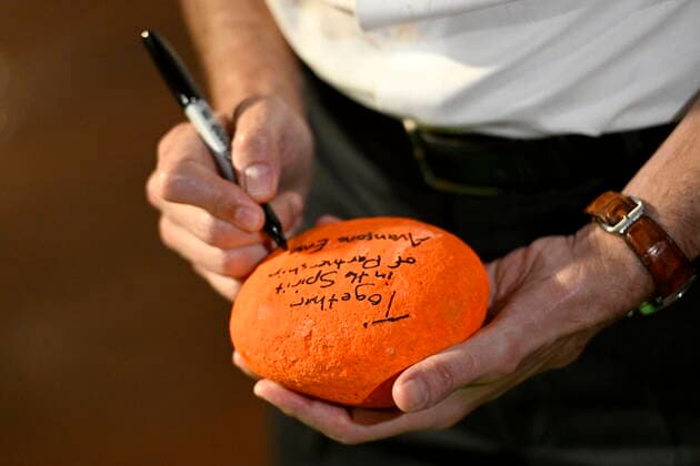 June 21, 2022, Ottawa, ON, CAN: Prime Minister Justin Trudeau writes a message of reconciliation, â€oeTogether in the spirit of partnership,†on a rock painted orange, at a community celebration of National Indigenous Peoples Day at MÄÂdaho²ko¬ Farm in Ottawa, on Tuesday, June 21, 2022. Ottawa CAN - ZUMAc35_ 20220621_zaf_c35_090 Copyright: xJustinxTangx
