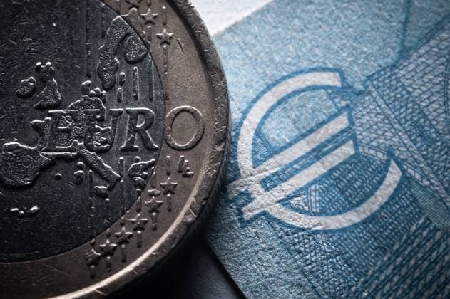 Der Schriftzug Euro ist auf einer 1-Euro Münze neben einem 20-Euro Schin in einem Büro zu sehen. Rottweil Baden-Württemberg Deutschland *** The lettering Euro can be seen on a 1 Euro coin next to a 20 Euro Schin in an office Rottweil Baden Württemberg Germany