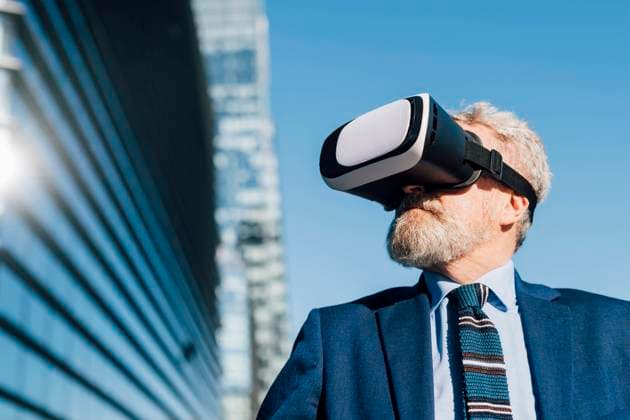 IMAGO Creative: Business - Progressive Geschäftsmodelle Senior businessman wearing virtual reality simulator outside office building exterior model released, Symbolfoto, MEUF06289