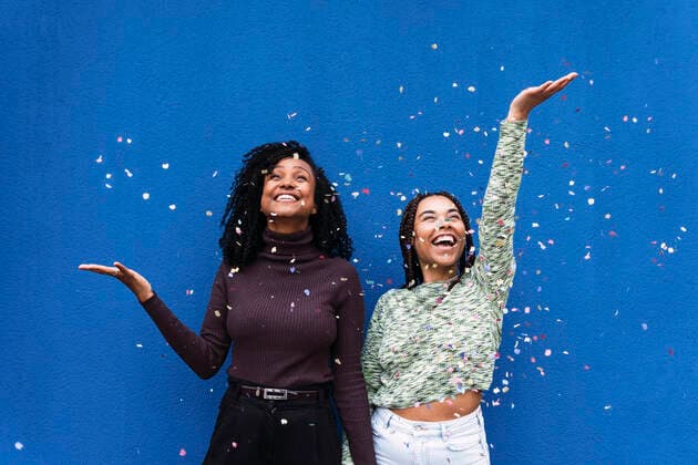 Creative Highlights Symbolbilder Happy friends throwing confetti standing in front of blue wall model released, Symbolfoto, PNAF03972
