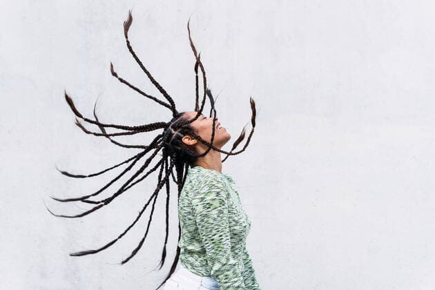 Creative Highlights Symbolbilder Happy young woman tossing braided hair against white background model released, Symbolfoto, PNAF04003