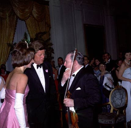Dinner in honor of AndrÃ Malraux, Minister of State for Cultural Affairs of France, 8:00PM. President John F. Kennedy and First Lady Jacqueline Kennedy visit with violinist Isaac Stern, following his performance at a dinner in honor of Minister of State for Cultural Affairs of France, AndrÃ Malraux. Those in background include: Secretary of the Interior, Stewart Udall; White House correspondent for Columbia Broadcasting System (CBS), George Herman; Dorothy LÃ ger, wife of poet Alexis LÃ ger (Saint-John Perse). East Room, White House, Washington, D.C. Copyright: xpiemagsx