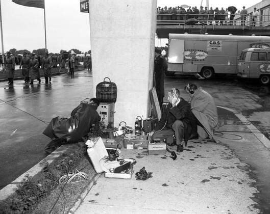 Trip to Europe: Arrival in Vienna, Austria 10:50AM; White House Army Signal Agency (WHASA) staff in Vienna. Two unidentified White House Army Signal Agency (WHASA) staff members use communications equipment for the arrival of President John F. Kennedy at Schwechat Airport in Schwechat, Austria; the President visited Vienna for a summit with Soviet Union Premier Nikita Khrushchev. A CBS Television News van is in the background. Copyright: xpiemagsx