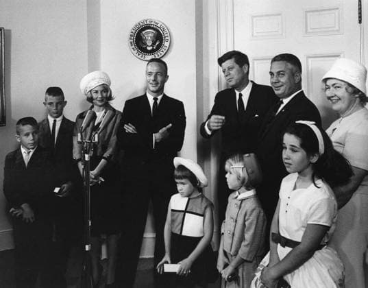 Visit of Astronaut Lt. Cmdr. Scott Carpenter family, 10:00AM. President John F. Kennedy visits with astronaut Lieutenant Commander M. Scott Carpenter and Director of Operations for Project Mercury, Dr. Walter C. Williams, and their families, regarding Lt. Cdr. Carpenters Mercury-Atlas 7 orbital flight (also known as Aurora 7). Left to right: Robyn Jay Carpenter, Marc Scott Carpenter, Rene Carpenter, Lt. Cdr. Carpenter, Candace Noxon Carpenter and Kristen Elaine Carpenter (both in front), President Kennedy, Dr. Williams, Elizabeth Ann Williams (in front), and Helen Manning Williams. Fish Room, White House, Washington, D.C. Copyright: xpiemagsx