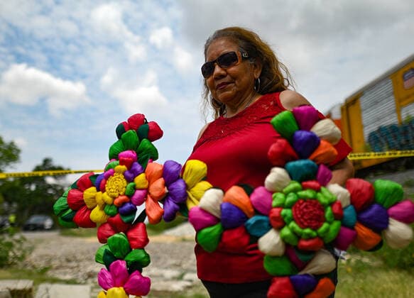 June 28, 2022, San Antonio, Texas, USA: ANGELITA OLVERA stands with flowers that she brought to lay at the scene on Tuesday, where 50 immigrants died a result as a result of heat in a trailer on Monday. San Antonio USA  - ZUMAa27_ 20220628_znn_a27_011 Copyright: xSanxAntonioxExpress-Newsx