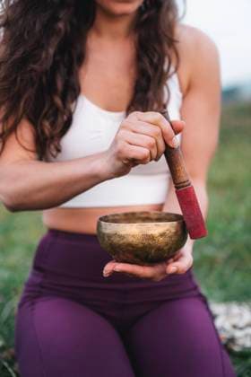 Unrecognizable female athlete in sportswear holding bell and meditating during yoga session in nature, Model released MikelQuina_AngelaYogaSea_00027.jpg Copyright: xMikelxQuinax MR