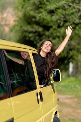 Optimistic Hispanic female traveler smiling with closed eyes and enjoying wind while peeking from RV window during road trip in nature on summer day, Model released OscarCarrascosa_CampingSession_18.jpg Copyright: xOscarxCarrascosax MR