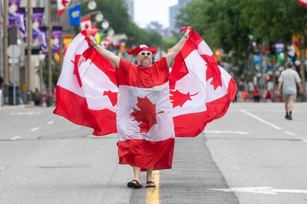 July 1, 2022, Ottawa, Ontario, Canada: A person wears several flags on Wellington street near the Parliamnet Hill during Canada Day in Ottawa on Friday July 1, 2022. Ottawa Canada  - ZUMAc35_ 20220701_zaf_c35_055 Copyright: xLarsxHagbergx