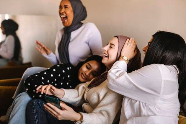 Creative Highlights Symbolbilder Young women laughing while sitting together on sofa at home Sweden, Gothenburg, model released, property released Copyright: xMaskotx , MA93329 MA93329