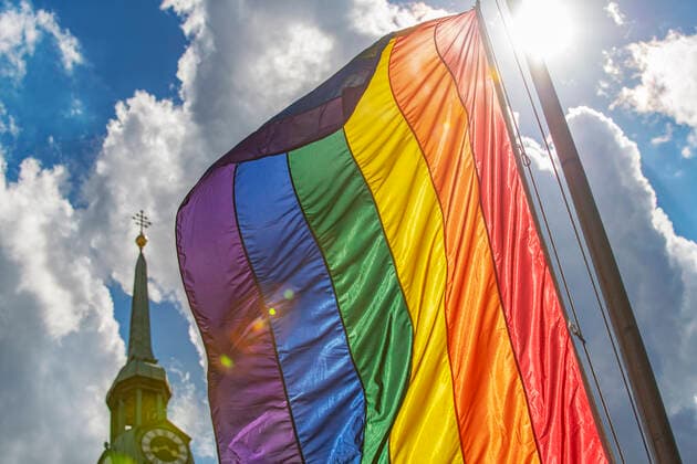 Regenbogenflagge am Marienplatz, Kirchturm Alter Peter, München, 5. Juli 2022 Deutschland, München, 5. Juli 2022, Regenbogenfahne auf dem Marienplatz, von der Sonne zum leuchten gebracht, Kirchturm Alter Peter im Durchblick, Symbolfoto, Vielfalt, Toleranz, Respekt, Anti-Diskriminierung, Diversity, Inklusion, Regenbogenfarben, Solidarität mit der LGBTQIA+ Community, internationales schwul-lesbisches Symbol, queer, Trans, Pride-Flagge, LGBT, LGBTQ, katholische Kirche, Maria 2.0, Religion, Bayern, Juli 2022, Querformat, *** Rainbow flag on Marienplatz, church tower Alter Peter, Munich, 5 July 2022 Germany, Munich, 5 July 2022, rainbow flag on Marienplatz, made to shine by the sun, church tower Alter Peter in view, symbol photo, diversity, t