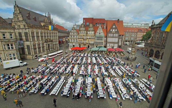 News Themen der Woche KW27 News Bilder des Tages Rund tausend Schulkinder haben am 7. Juli 2022 auf dem Bremer Marktplatz an langen Tischen Schach gespielt. Nach Angaben der Bremer Bildungsbehörde handelte es sich dabei um das bundesweit größte Projekt dieser Art - unter der Devise Schach macht schlau! Es startete im Schuljahr 2018 19 an Grundschulen in Bremen und Bremerhaven. Mittlerweile beteiligen sich daran 152 Klassen an 37 Schulen mit 3.300 Kindern. Alle teilnehmenden Klassen spielen eine Stunde pro Woche Schach im Unterricht. Das Ziel des Projekts laut Bildungsbehörde: Stärkung der Bildungschancen aller Kinder und Verbesserung schulischer Leistungen. Zu den Veranstaltern des Massenschachs zählte die Bremer Bildungssenatorin Sascha Karolin Aulepp (SPD) und der Verein Das erste