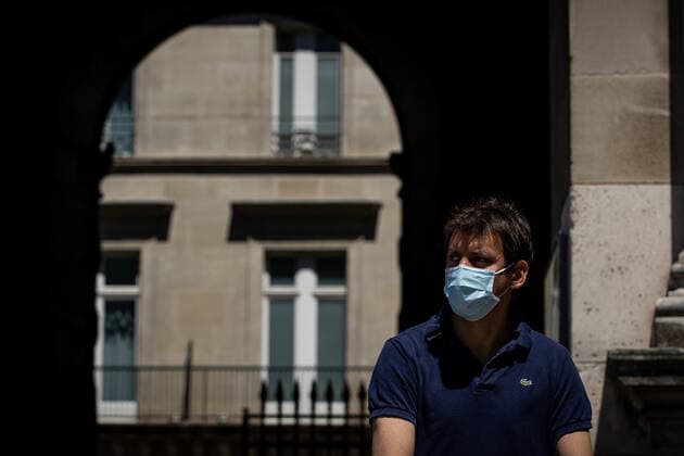 (220709) -- PARIS, July 9, 2022 -- A man wearing a face mask walks on a street in Paris, France, July 8, 2022. The total number of COVID-19 related deaths in France passed the 150,000 mark on Friday, after 74 deaths related to the virus were recorded in hospitals in the past 24 hours, announced the country s public health agency. (Photo by Xinhua) FRANCE-PARIS-COVID-19-DEATH AurelienxMorissard 