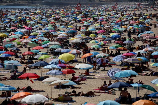 IMAGO Nature: Unsere Erde, Umweltprobleme, Überbevölkerung Portugal on wildfire alert amid heat wave and severe drought Beachgoers crowd the Carcavelos beach during a hot afternoon in Cascais, near Lisbon, Portugal, on July 9, 2022. Portugals government on Friday declared an eight-day state of alert due to the heightened risk of wildfires, as the drought-stricken country prepares for a heat wave packing temperatures as high as 43 degrees Celsius. Lisbon Portugal  Copyright: xPedroxFiuzax originalFilename: fiuza-portugal220709_npjE3.jpg