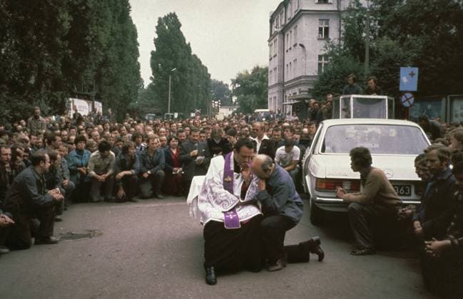 Anefo photo collection. Strikes in Poland 1980: Leninwerf Gdansk. Priest Henryk Jankowski decides in the middle of kneeling workers of the Leninwerf; At the left rear it with microphone strike leader Lech Walesa. August 20, 1980. Gdansk, Poland Copyright: xpiemagsx pienatarchpart1270921-48317 !ACHTUNG AUFNAHMEDATUM GESCHÄTZT!