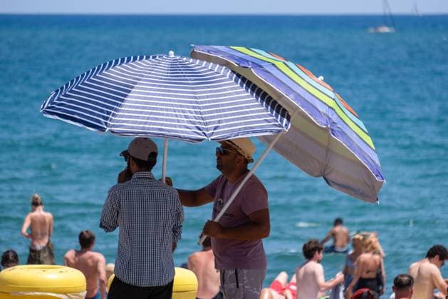 July 11, 2022, Barcelona, Catalonia, Spain: Beach umbrella vendors are seen on Barceloneta beach. Second wave of extreme heat that may exceed 44 degrees Celsius in some regions of Spain. Catalonia, currently at level one and after weeks of accumulating high temperatures and little rain, will suffer this week some days of temperatures above what is usual for these dates Barcelona Spain - ZUMAs197 20220711_zaa_s197_247 Copyright: xPacoxFreirex
