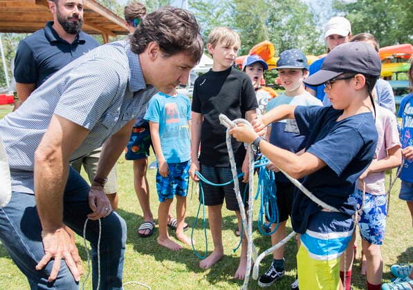 July 12, 2022, Magog, PQ, Canada: Prime Minister Justin Trudeau is shown how to make a knot by a young boy during a visit to a sailing camp in Magog, Que., Tuesday, July 12, 2022. Magog Canada  - ZUMAc35_ 20220712_zaf_c35_049 Copyright: xGrahamxHughesx