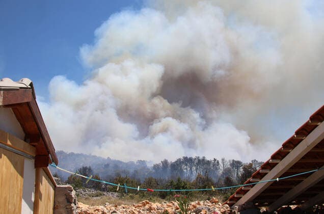 PXL_A fire near Vodice, Croatia Fire in an open area near the Velika Mrdakovica archaeological site in the Vodice hinterland, Croatia on July 13, 2022. About 30 firefighters with a dozen vehicles are on the ground, and two Canadairs joined the ground forces in extinguishing the fire. There are pine forests above, low vegetation, and endangered buildings. DuskoxJaramaz PIXSELL