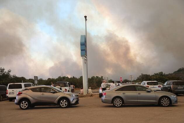 (220713) -- ZATON (CROATIA), July 13, 2022 -- People park their vehicles on the roadside as heavy smoke rises in the background in Zaton, Croatia, on July 13, 2022. ( via Xinhua) CROATIA-ZATON-FIRE DuskoxJaramaz PIXSELL 