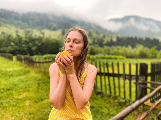 Creative Highlights Symbolbilder A beautiful woman holding an orange on the background of the mountains Ivano-Frankivsk, Ivano-Frankivsk Oblast, Ukraine CR_VZYA220713-1007343-01 ,model released, Symbolfoto