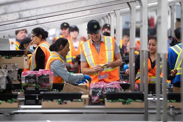 July 18, 2022, KELOWNA, BC, CANADA: Prime Minister Justin Trudeau helps workers prepare bags to pack cherries during a visit to the B.C. Fruit Growers packing plant in Kelowna, B.C., on Monday, July 18, 2022. KELOWNA CANADA  - ZUMAc35_ 20220718_zaf_c35_047 Copyright: xDarrylxDyckx