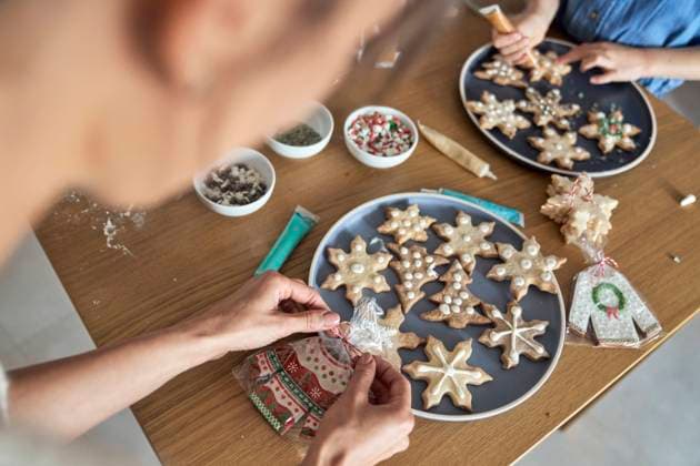 Woman packing homemade gingerbread cookies by girl decorating at home model released, Symbolfoto property released, ABIF01779