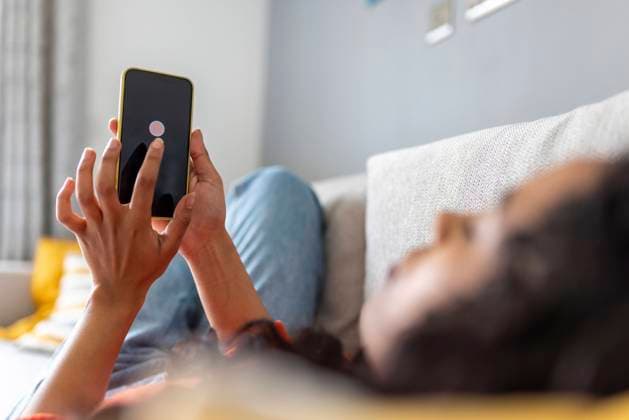 IMAGO Creative, Lifestyle, Tik Tok-Trend thatgirl IMAGO Creative: Business, Innovative Technologie-Lösungen Woman turning off mobile phone using smart phone in living room model released, Symbolfoto property released, WPEF06007