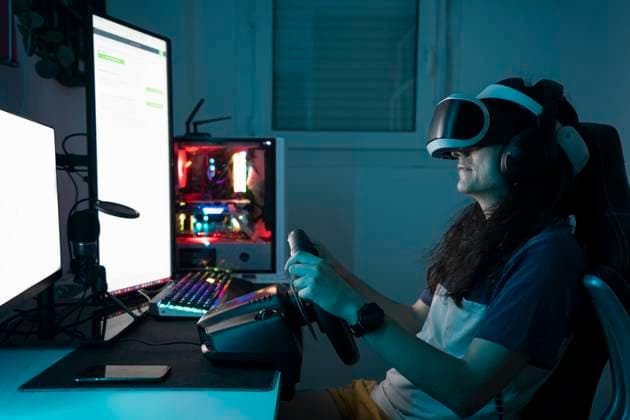 IMAGO Creative, Lifestyle, Gaming Man wearing VR glasses using steering wheel sitting at home model released, Symbolfoto property released, DAMF00999