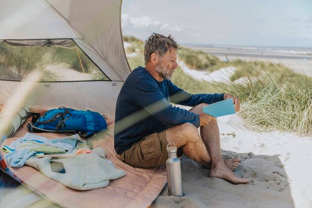 Mature man reading book at beach on sunny day model released, Symbolfoto, MFF09226