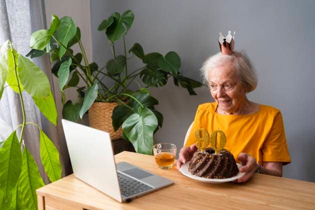 Happy senior woman showing birthday cake on video call through laptop at home model released, Symbolfoto property released, SVKF00360