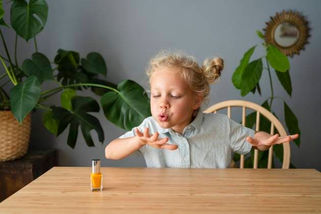 Girl blowing on painted nails sitting at home model released, Symbolfoto property released, SVKF00388