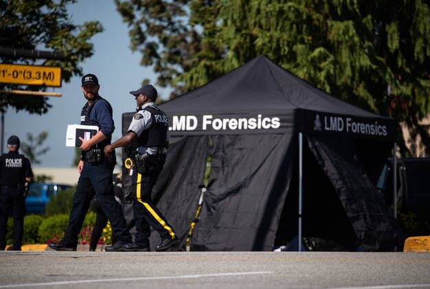 July 25, 2022, LANGLEY, BC, CANADA: RCMP officers talk as a tent covers a body at the scene of a shooting, in Langley, B.C., on Monday, July 25, 2022. A suspect is in custody after several people were shot in the Metro Vancouver city of Langley, RCMP said. Police issued a blaring cellphone alert at about 6:20 Monday morning, saying they were at the scenes of several shootings involving transient victims. LANGLEY CANADA - ZUMAc35_ 20220725_zaf_c35_121 Copyright: xDarrylxDyckx