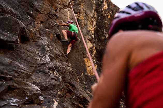Creative Highlights Symbolbilder Low angle view of active senior male and female climbers climbing on rocky cliff, Model released CienXCienStudio_Climbing_00024.jpg Copyright: xCienxXxCienxStudiox MR
