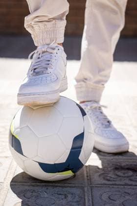 Creative Highlights Symbolbilder Cropped unrecognizable of young man with foot over football standing on footpath, Model released HarryRendon_FootbalPlayer_42.jpg Copyright: xHarryxRendonx MR