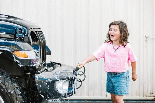 Creative Highlights Symbolbilder Happy Caucasian girl in casuals washing car with hose on road, Model released HodeiUnzueta_CleanCar_00036.jpg Copyright: xHodeixUnzuetax MR
