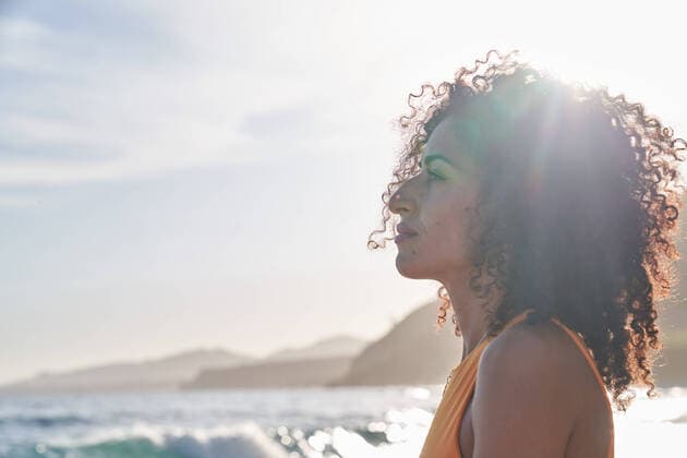 Creative Highlights Symbolbilder Hispanic female with curly hair looking away while standing by the sea on a sunny day, Model released JavierBermudez_SanaBeach_00020.jpg Copyright: xJavierxBermudezx MR