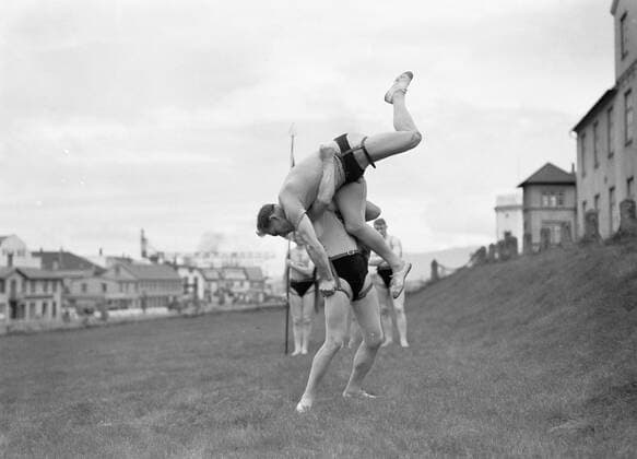 Poll photo collection. Iceland. Reykjavik. Icelandic wrestling (Glima). Two members of the Glimateam of the Menntaskolinn in Aktie. The other team members, one with a banner, look. 1934. Iceland, Reykjavik Copyright: xpiemagsx pienatarchpart630102021-18606 !ACHTUNG AUFNAHMEDATUM GESCHÄTZT!