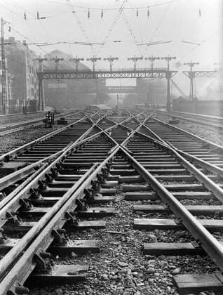 Poll photo collection. Reporting Dutch Railways. Railway pelaming with rails, points and above the electricity cables and in the background the station halls of the central station. 1932. Amsterdam, Noord-Holland Copyright: xpiemagsx pienatarchpart630102021-21966 !ACHTUNG AUFNAHMEDATUM GESCHÄTZT!