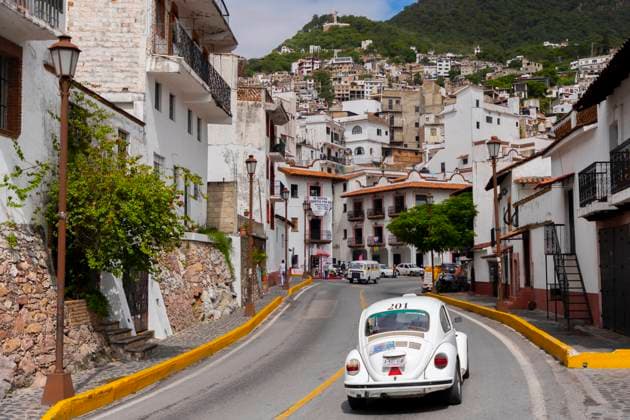 Taxco, Mexico July 16, 2022 - A retro style Vocho (Volkswagen Beetle) rides in a street of the the historic center. The city of Taxco, founded in 1528 following the discovery of silver mines, is classified among the Pueblos Magicos (Magical Towns) thanks to the unity of its colonial architecture. TAXCO, MEXIQUE, ETAT DE GUERRERO, DESTINATION DE VOYAGE, TOURISME, PUEBLO MAGICO, AMERIQUE LATINE, ILLUSTRATION, GENERIQUE, ARCHITECTURE, VILLE COLONIALE, SITE TOURISTIQUE, CULTURE MEXICAINE, PATRIMOINE, QUARTIER HISTORIQUE, VISITER, EVASION, VOLKSWAGEN BEETLE, VOCHO Copyright: xVincentxIsorex