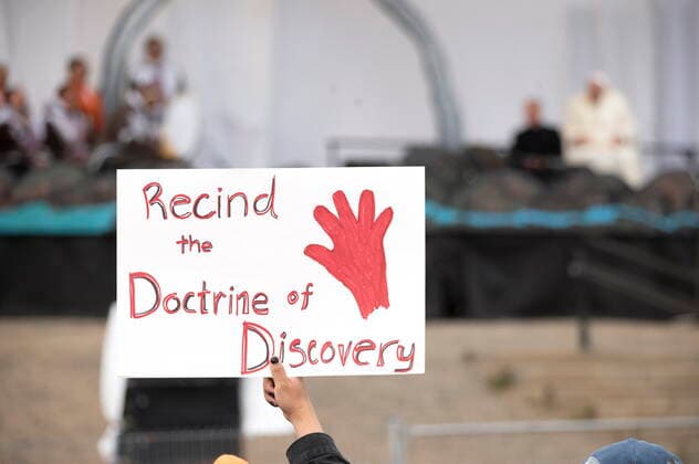 July 29, 2022, IQALUIT, NU, CANADA: A protester holds a sign as Pope Francis takes part in a public event in Iqaluit, Nunavut on Friday, July 29, 2022, during his papal visit across Canada. IQALUIT CANADA  - ZUMAc35_ 20220729_zaf_c35_078 Copyright: xDustinxPatarx