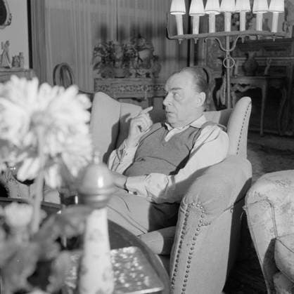 Poll photo collection. Visit to the German author Erich Maria Remarque and the American actress Paulette Goddard in their villa in the Swiss Porto Ronco. Remarque in conversation, sitting in an armchair in his living room in the villa in Porto Ronco. October 1961. Lago Maggiore, Switzerland Copyright: xpiemagsx pienatarchpart630102021-32759 !ACHTUNG AUFNAHMEDATUM GESCHÄTZT!