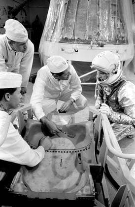 S63-03968 (1963) --- Astronaut L. Gordon Cooper Jr., prime pilot for the Mercury-Atlas 9 (MA-9) mission; Joe Trammel, MAC technician; A. Rochford, NASA suit technician; and C.R. Coyle, MAC technician, look over spacecraft couch. Copyright: xpiemagsx piemagsspace-1031 !ACHTUNG AUFNAHMEDATUM GESCHÄTZT!