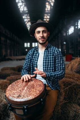  IMAGO Creative: 2022 Favoriten  IMAGO Creative: Lokalhelden - Kunst und Kultur Young male drummer against african wooden drum, Young male drummer against african wooden drum, factory shop on background. Djembe, musical percussion instrument, Young male drummer against african wooden drum, factory shop on background. Djembe, musical percussion instrument model released, Symbolfoto , 05.02.2020, Copyright: xNomadSoulx Panthermedia28062839.jpg