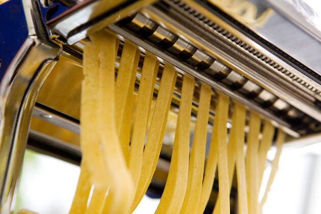 Fettuccine coming out of a manual pastamachine - shallow depth of field with focus on the pasta Copyright: 30240458