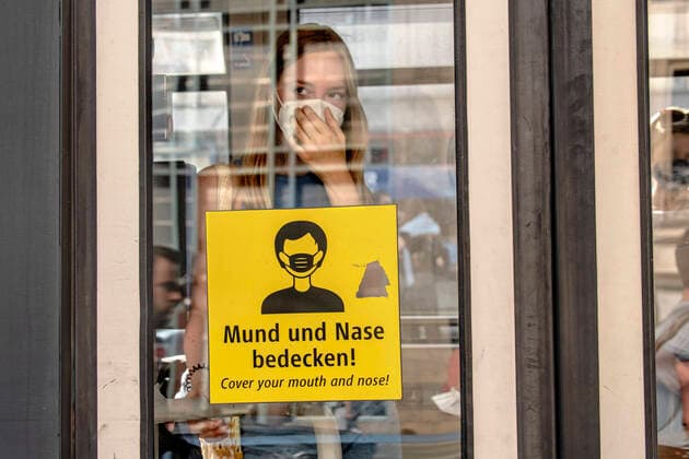 young woman with mask in the streetcar, sign for mask obligation in public transport, Munich, 13 August 2022 Germany, Munich, 13 08 2022, young woman puts on her FFP2 mask in the streetcar after boarding, sign cover mouth