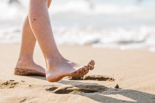 Creative Highlights Symbolbilder Crop anonymous barefoot kid strolling on sandy shore near waving sea on blurred background in tropical resort on summer day in Getaria Zarautz, Model released HodeiUnzueta_GetariaZarautz_38.jpg Copyright: xHodeixUnzuetax MR