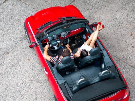 Sommer in Berlin - Cabrio fahren - CREATIVE Berlin, Deutschland - 16. August 2022: (CREATIVE) Ein Paar (junger Mann und junge Frau) geniessen den Sommer in einem BMW Mini Cabriolet. (Photo: Christian Ender) Berlin