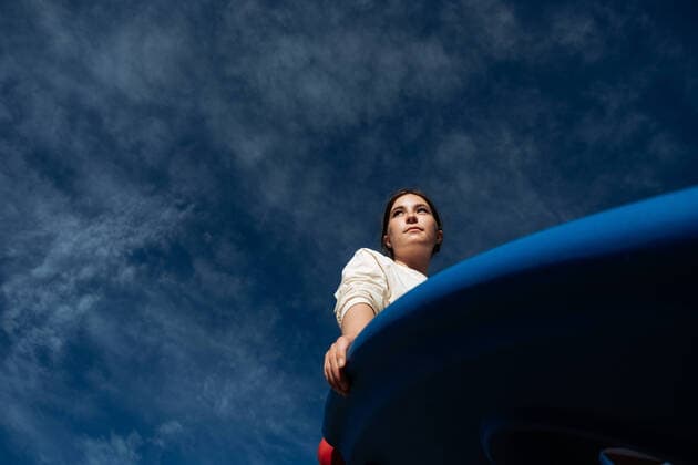 Creative Highlights Symbolbilder Looking up at teen girl sitting on a sunny day with blue sky Denver, Colorado, United States CR_JEMI220816-1025471-01 ,model released, Symbolfoto