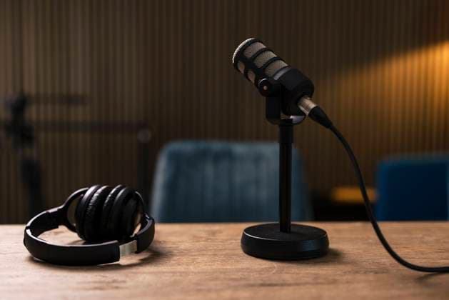 Microphone by headset on desk in recording studio property released, JOSEF11148