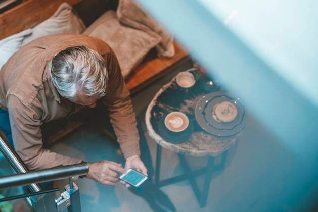 IMAGO Creative: Business, Innovative Technologie-Lösungen Senior man text messaging on smart phone at cafe model released, Symbolfoto property released, JOSEF11561
