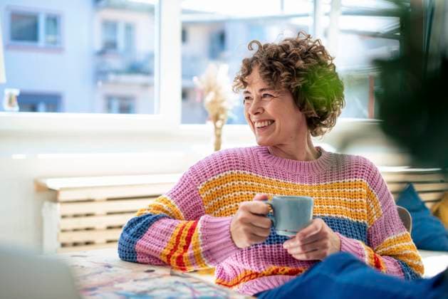 Happy mature woman with coffee cup sitting at home model released, Symbolfoto property released, JOSEF11637